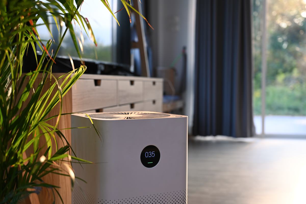 A freestanding air purifier with a digital display in a living room