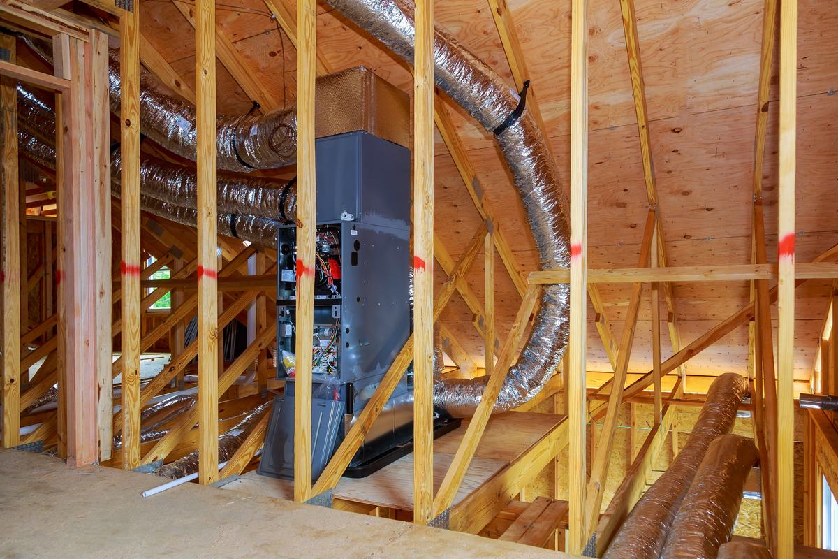 A furnace and flexible ducts installed in a newly framed home