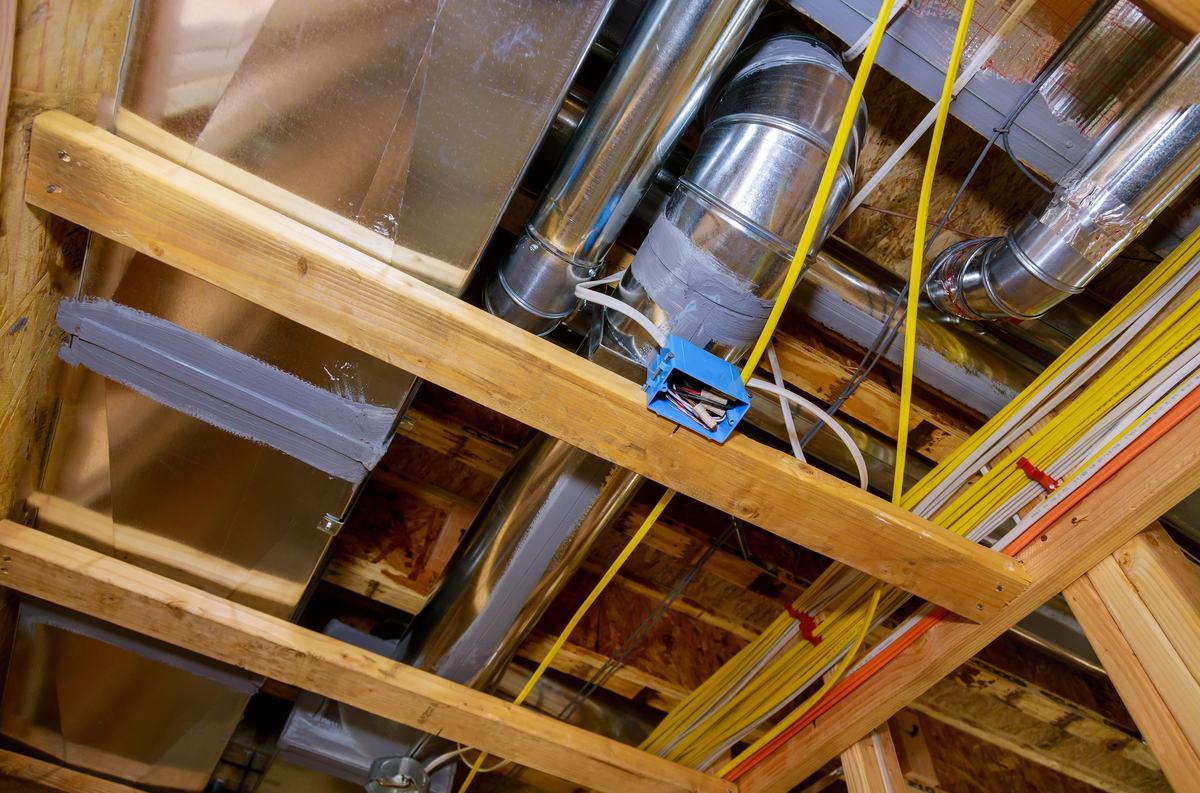 Heating and ventilation ductwork running through the floor framing of a new home