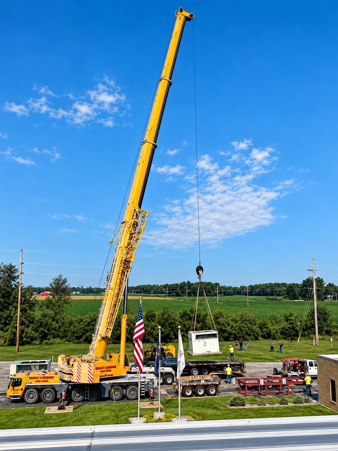 A crane lifting a rooftop HVAC unit at a commercial building in the countryside