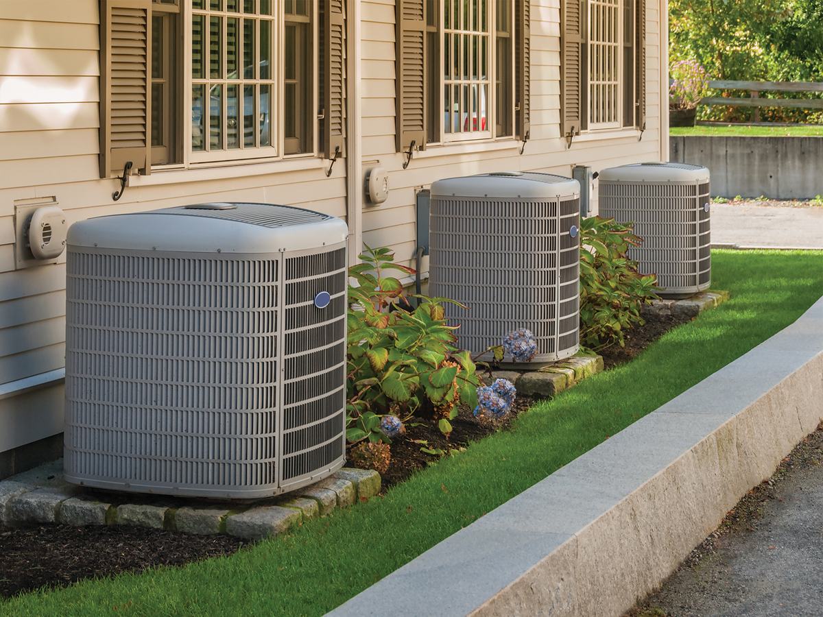 Central air conditioner condensers installed beside a home