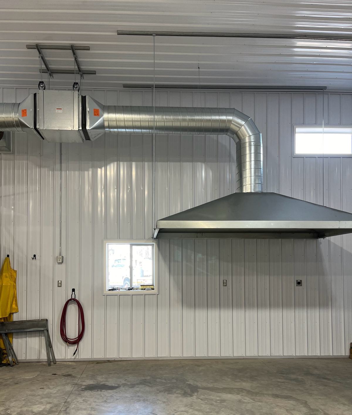 A ventilation hood and exhaust ductwork in a commercial shop